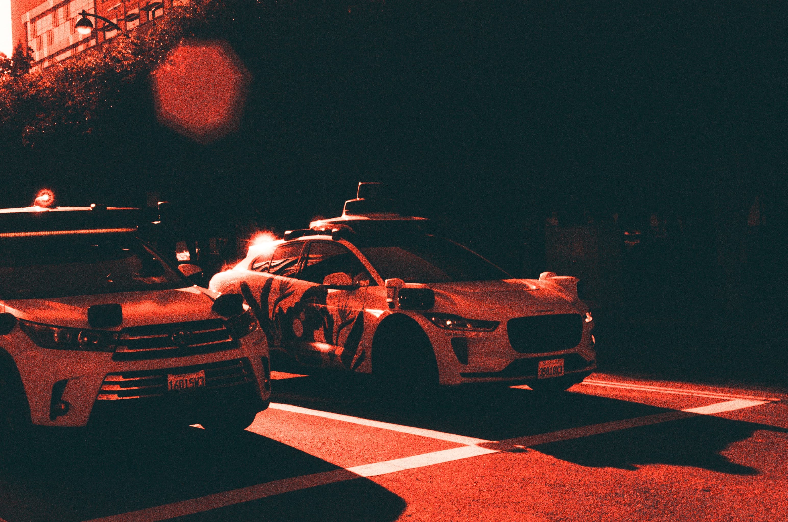 Autonomous cars at night photographed in red and black