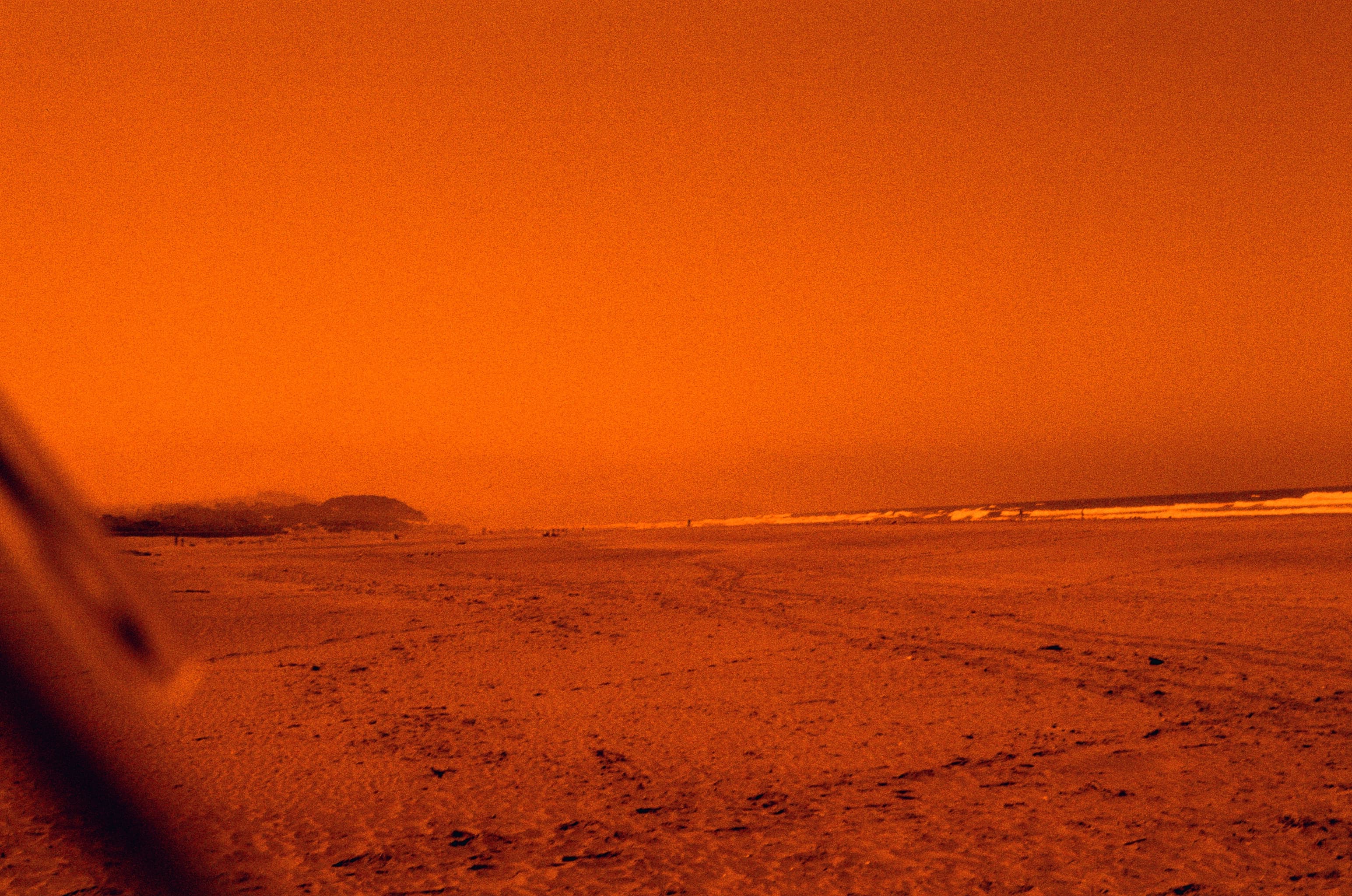 A wide beach landscape photographed in orange